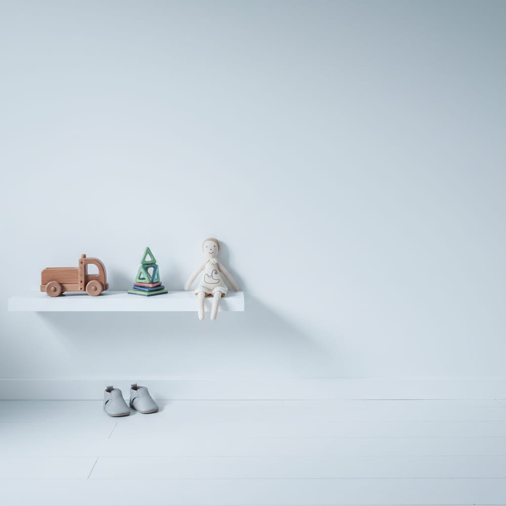 A bright, nearly empty child's shelf holding a few well-chosen toys